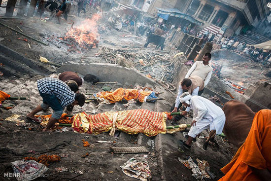 محل مرده سوزانی در شهر بنارس هند، مرده ایی در حال سوختن  و مردگانی که بعد از غسل در رود گنگ آماده سوزاندن می شوند